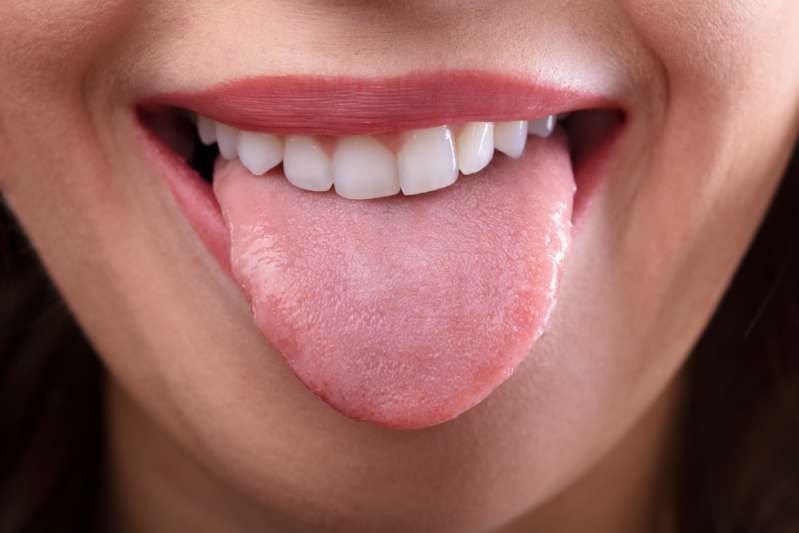 Når tenner merker på tungen signaliserer helseproblemer? Nærbilde av en kvinne